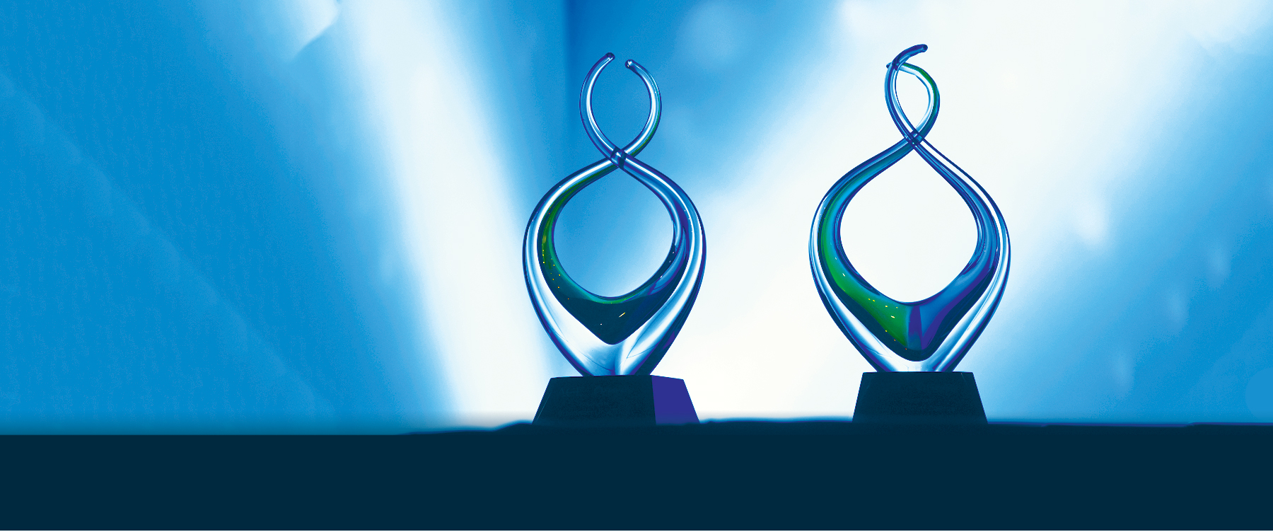 A picture of glass award sculptures on a table