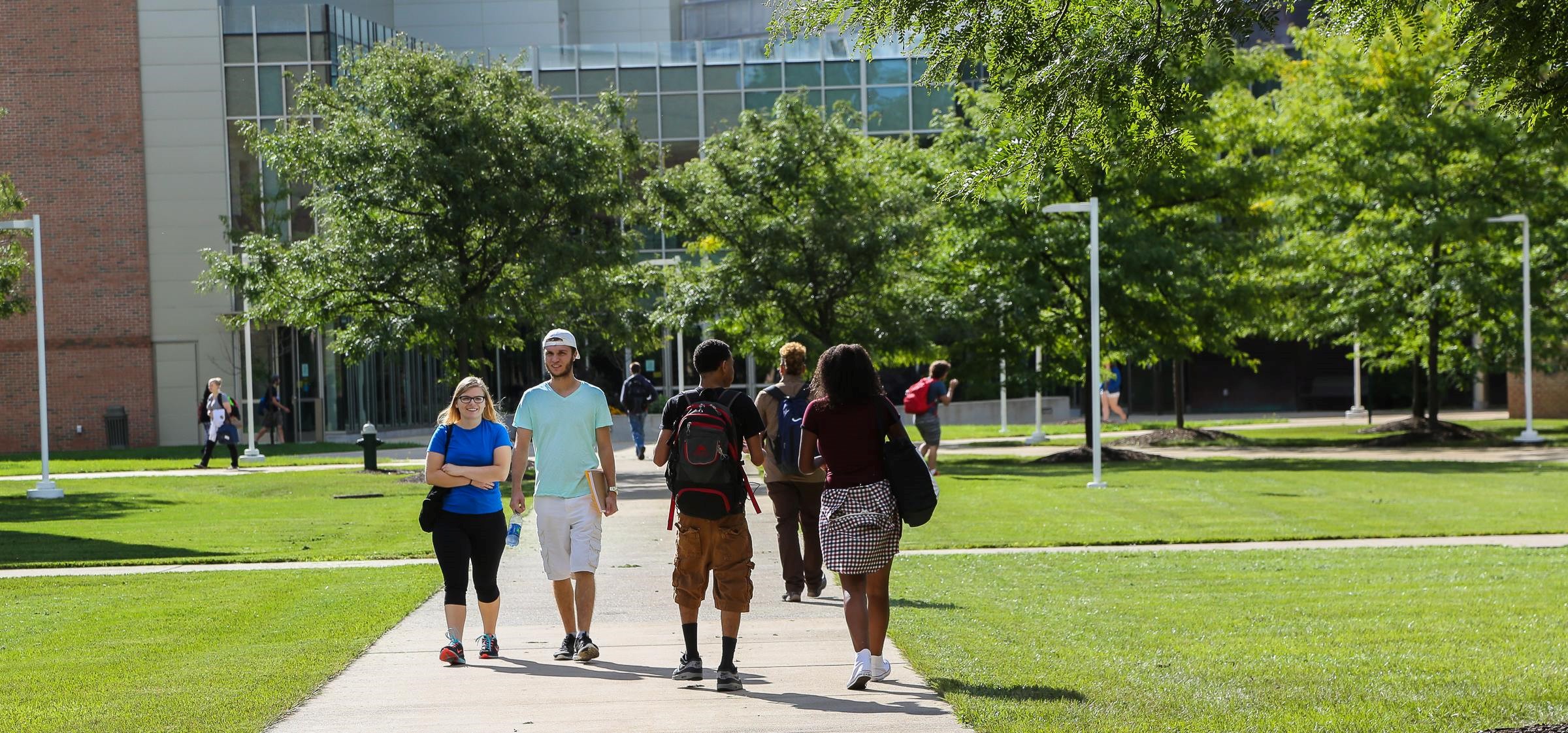 Photo of students walking on a campus quad on a bright day