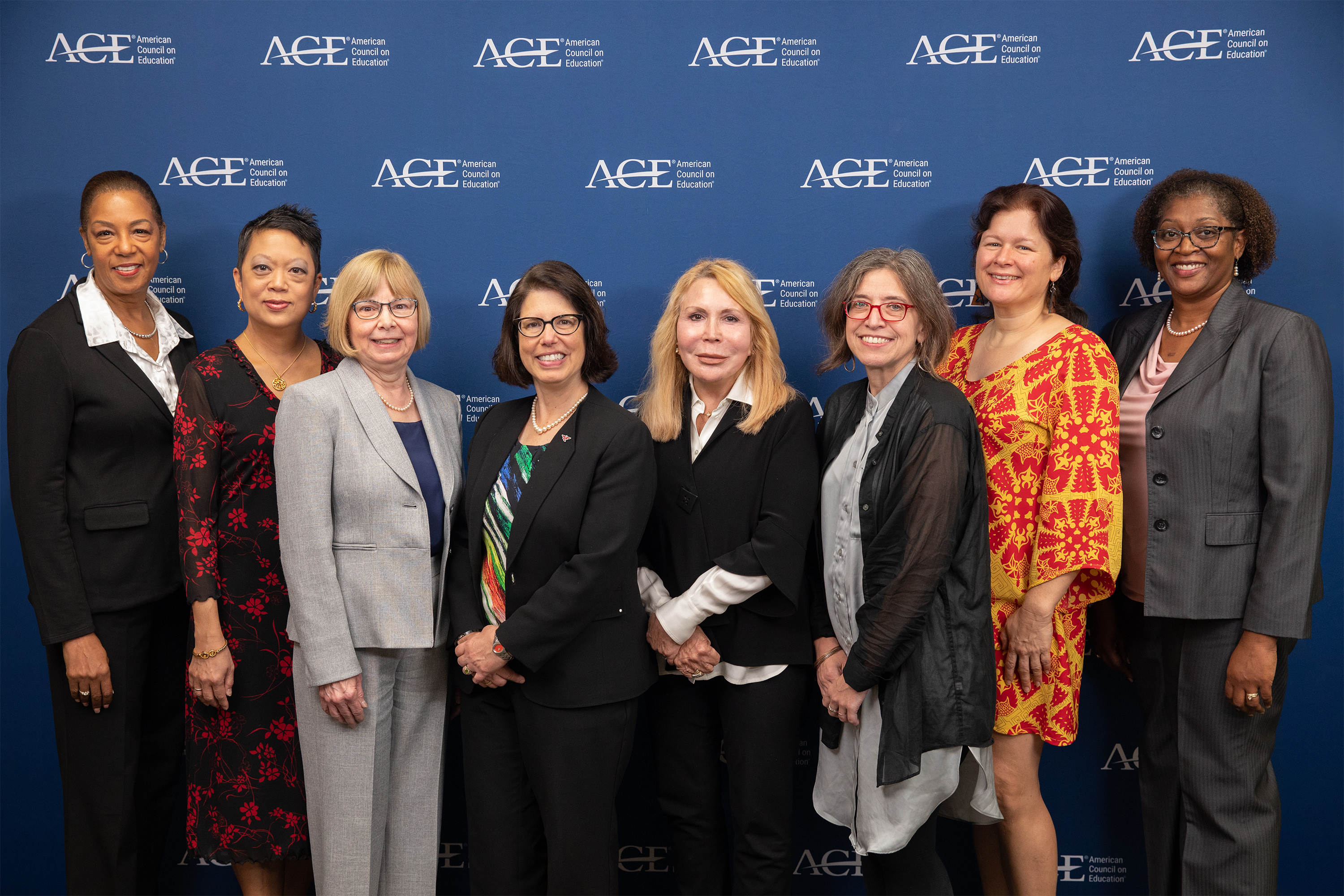The Women's Executive Council stands in front of a backdrop for a group photo in 2023