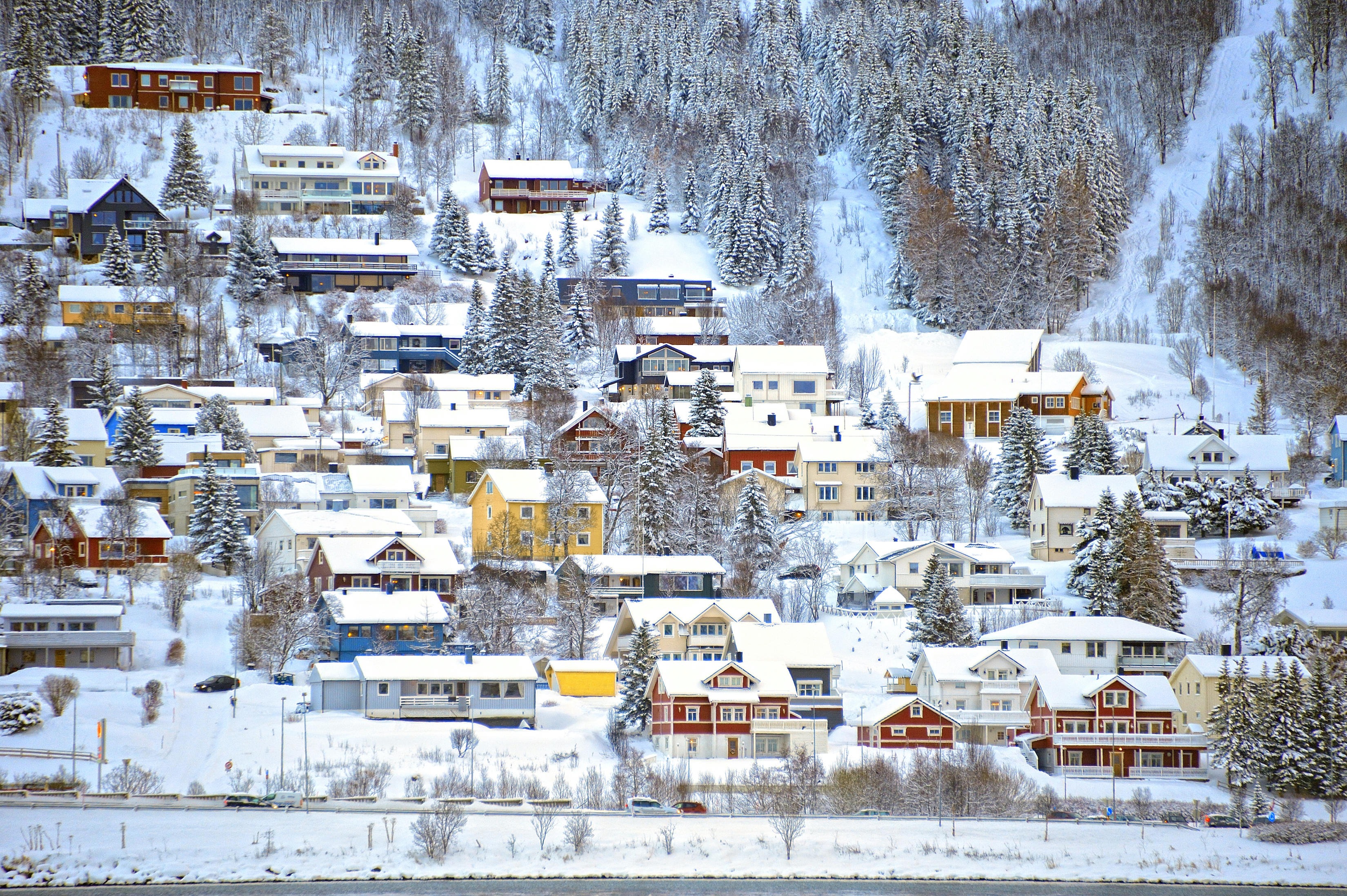Picture of snowy houses oh a hillside in Tromso, Norway.