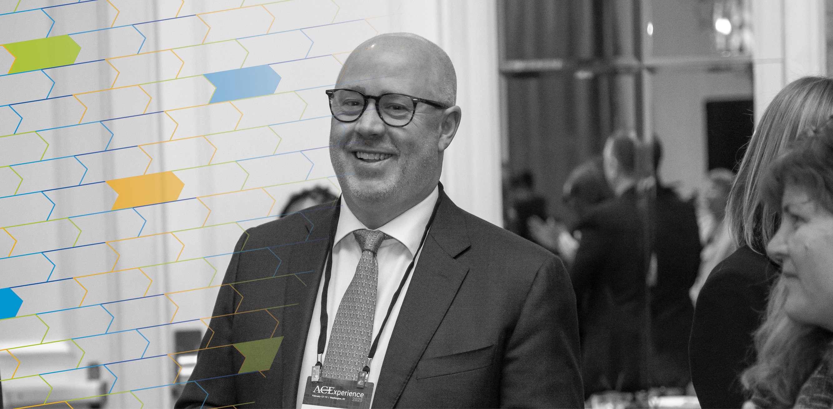 Black and white photo of a man in a suit attending the ACE Experience.