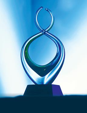 Photo of a glass award sculpture in front of blue backdrop