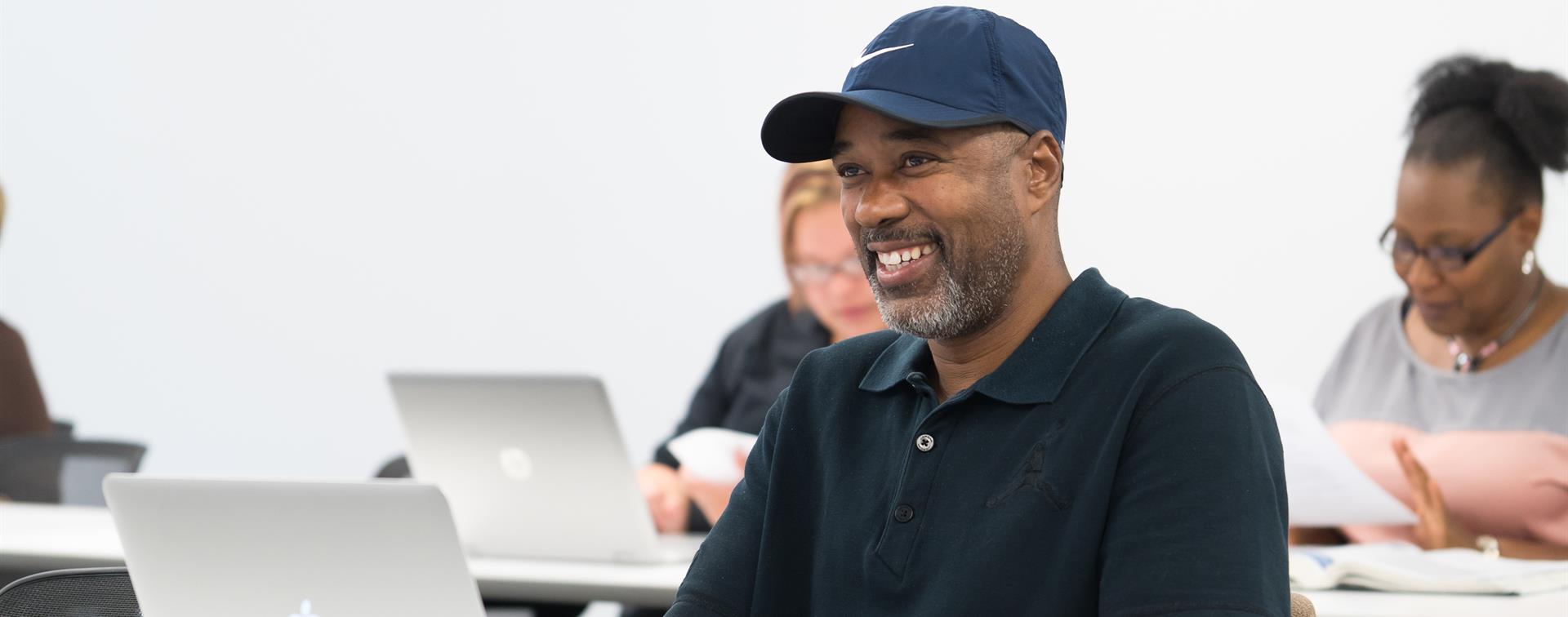 Picture of a man wearing a baseball cap and smiling. 