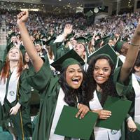 Twos smiling female graduates of Binghampton University posing at graduation ceremony