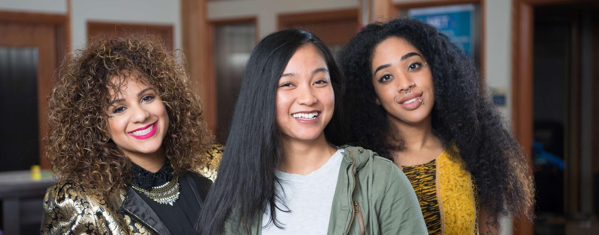 A picture of three students posing and smiling. 