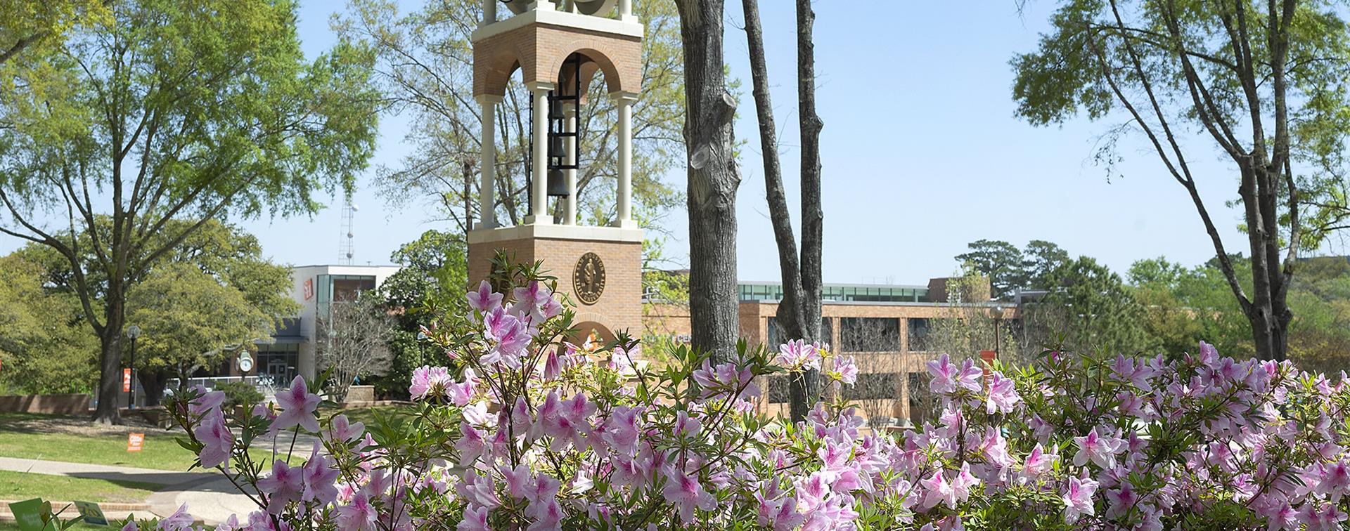 Image of a building on SHSU's campus with blooming trees in front of it.
