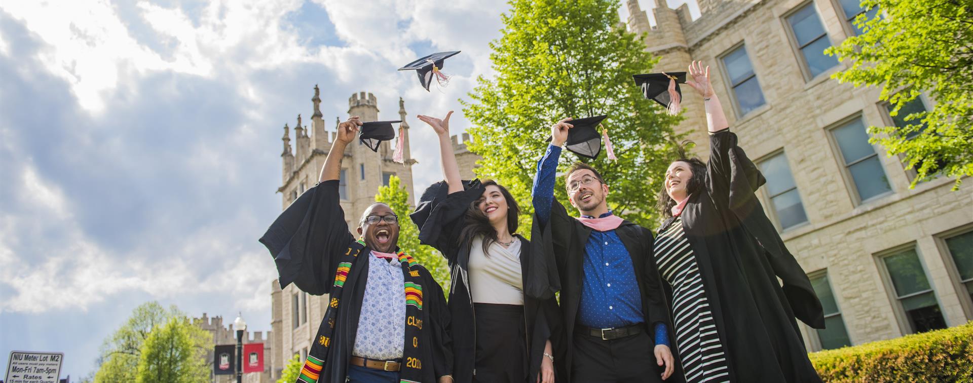 Picture of students on graduation day throwing caps into the air. 