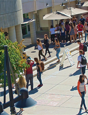 Picture of a campus center with students walking.