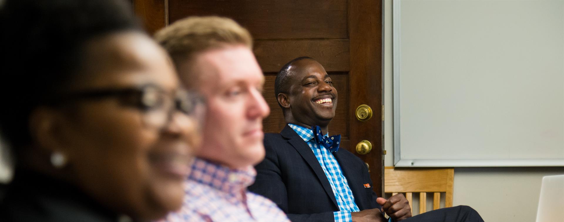 Men smiling around a table