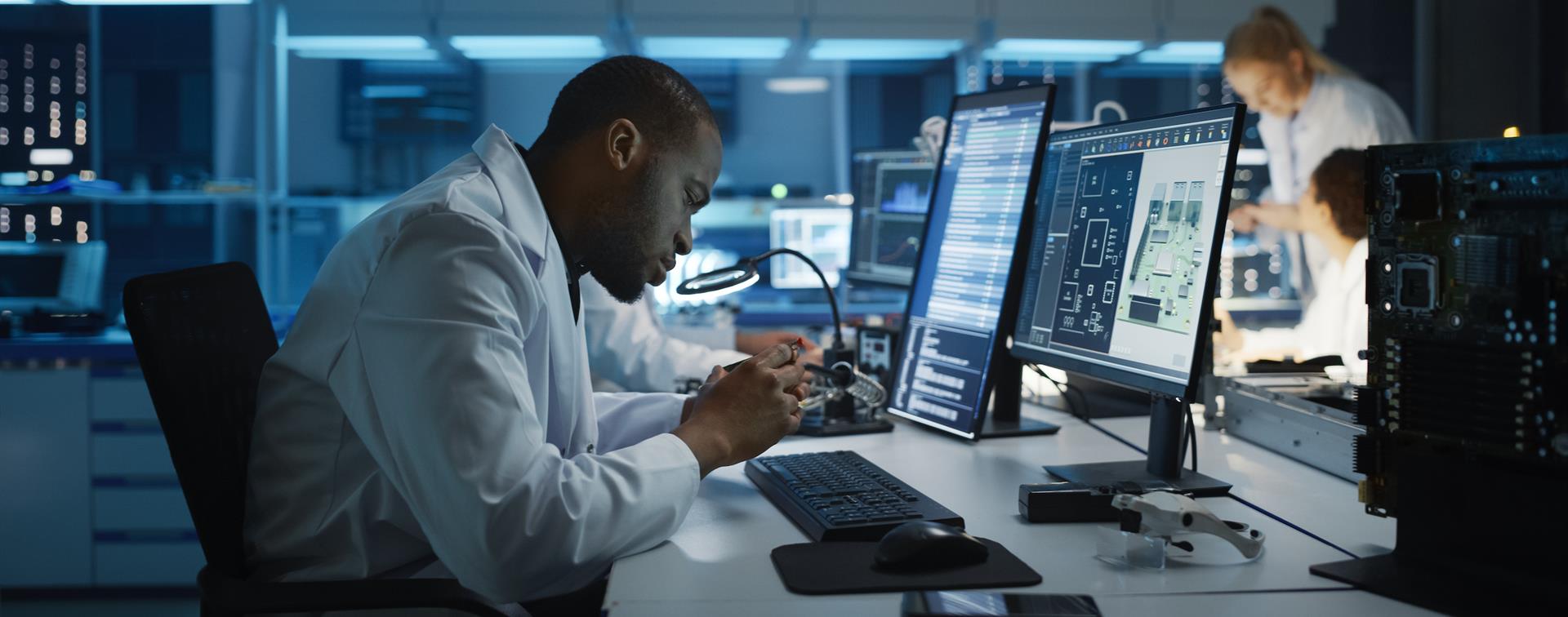 Photo of an adult student in a lab studying a circuit