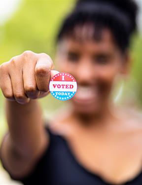 Picture of young woman holding "I Voted" sticker