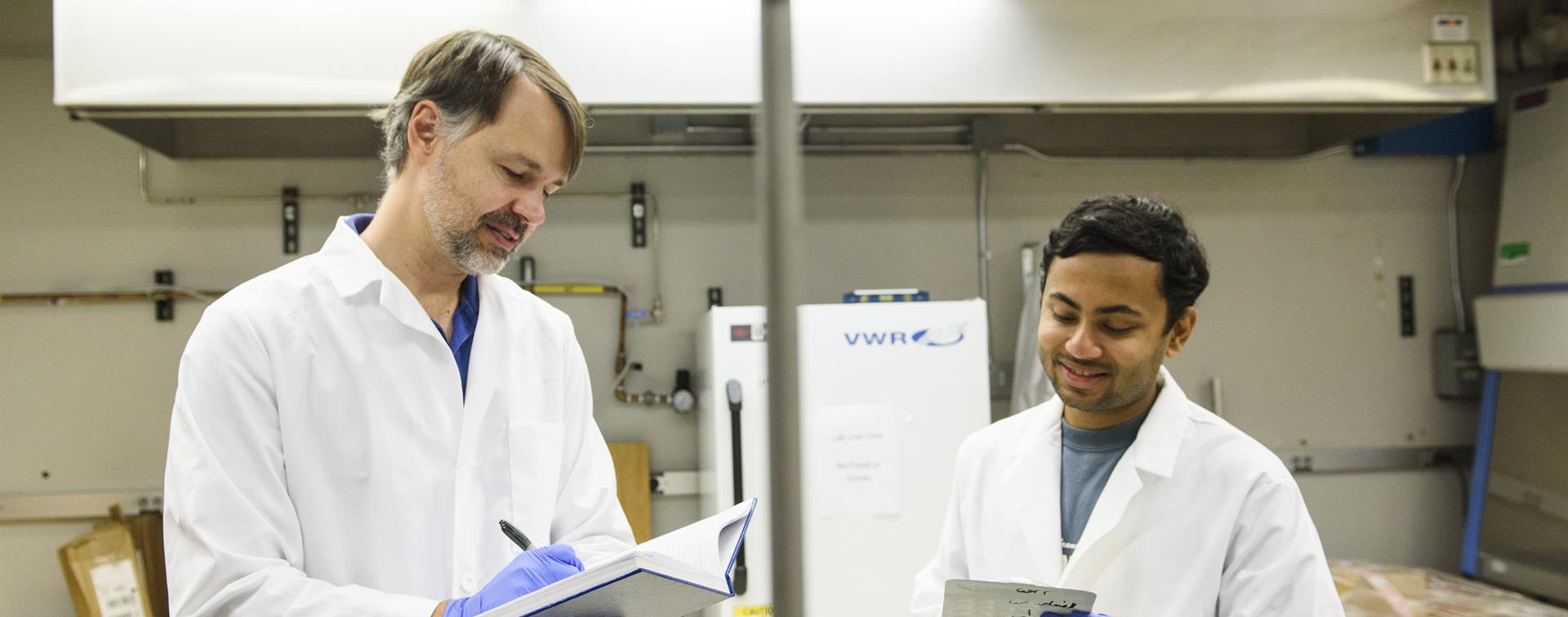 Dr. Mark Elliott works with a student in a lab at the University of Alabama