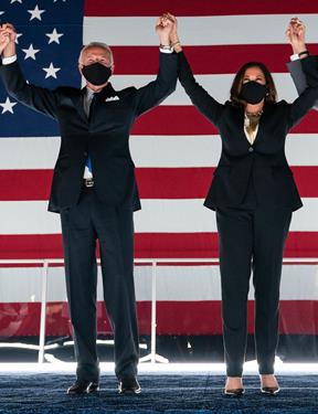 Picture of Joe Biden and Kamala Harris holding hands and raising them in the air. 