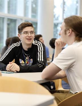 Students sit together at a round table.