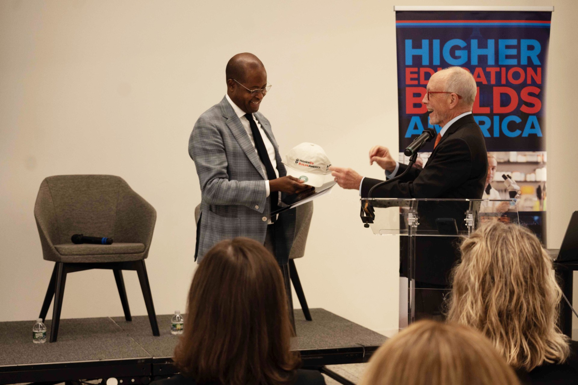 Ted Mitchell gives Howard University President Wayne A.I. Frederick a "Higher Education Builds America" cap