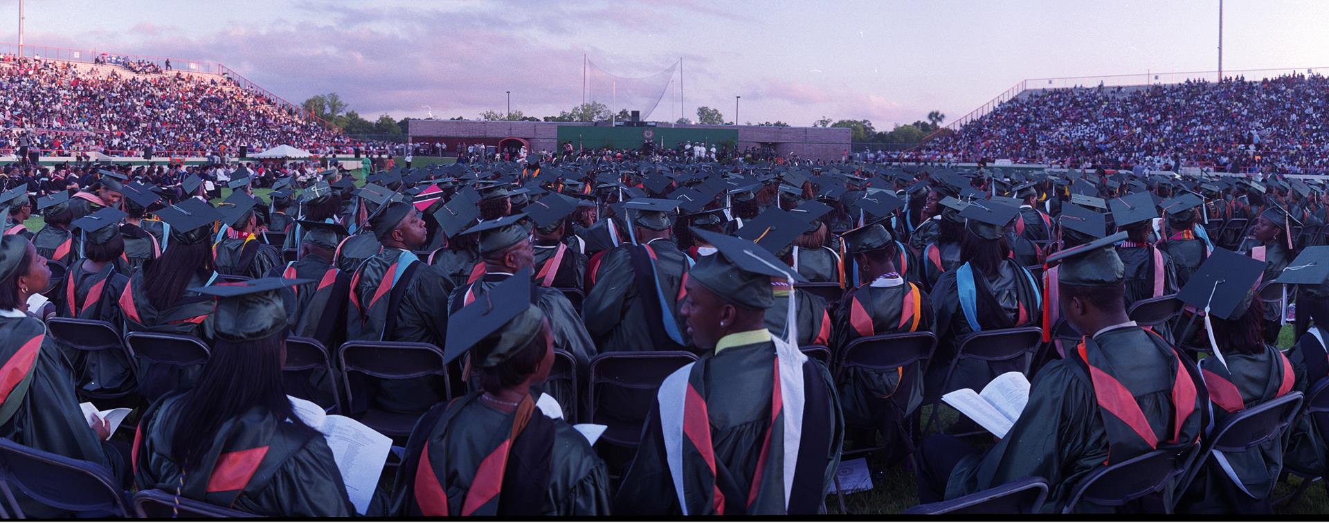 A large group of students sitting in graduation garments for Florida A&M at an outdoor ceremony