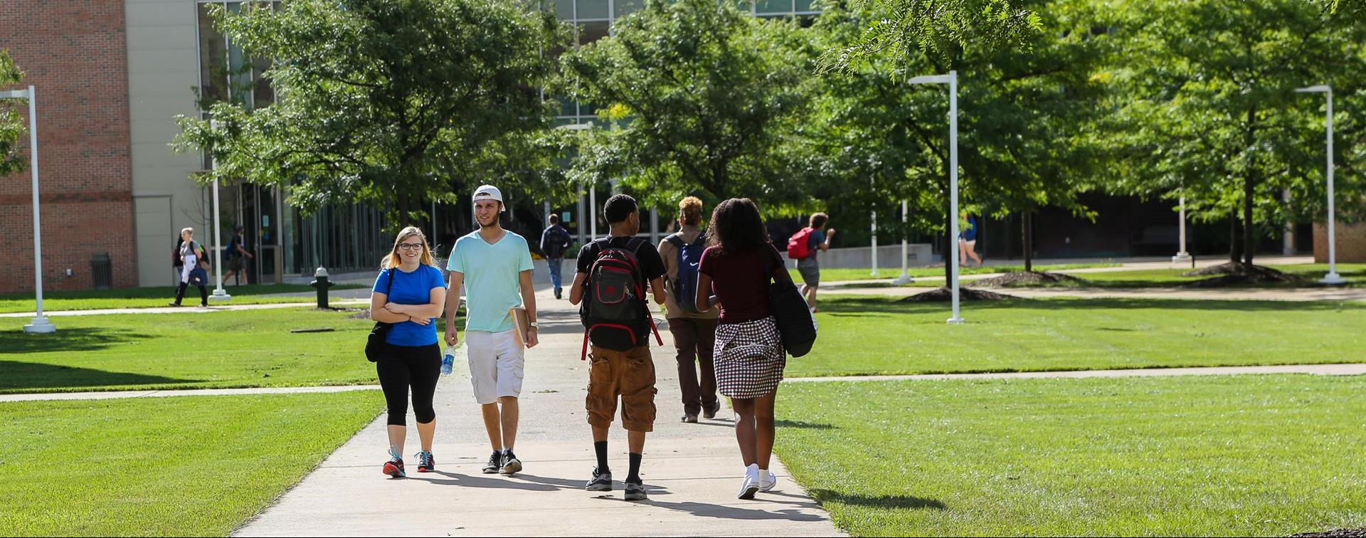 Photo of students walking on a campus quad on a bright day