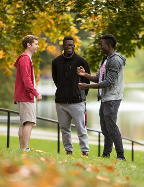 Picture of three students on campus having a conversation.