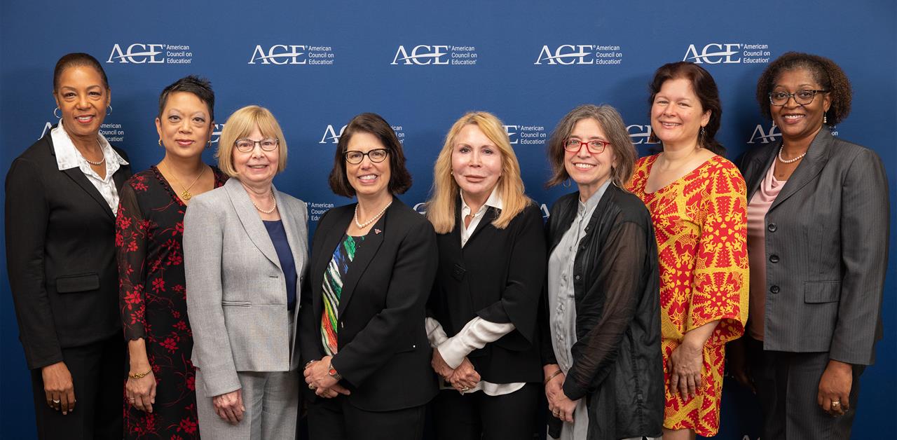 The Women's Executive Council stands in front of a backdrop for a group photo in 2023