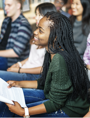 Picture of a student sitting in class with a notebook. 