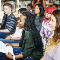 Picture of a smiling female student seated among other students