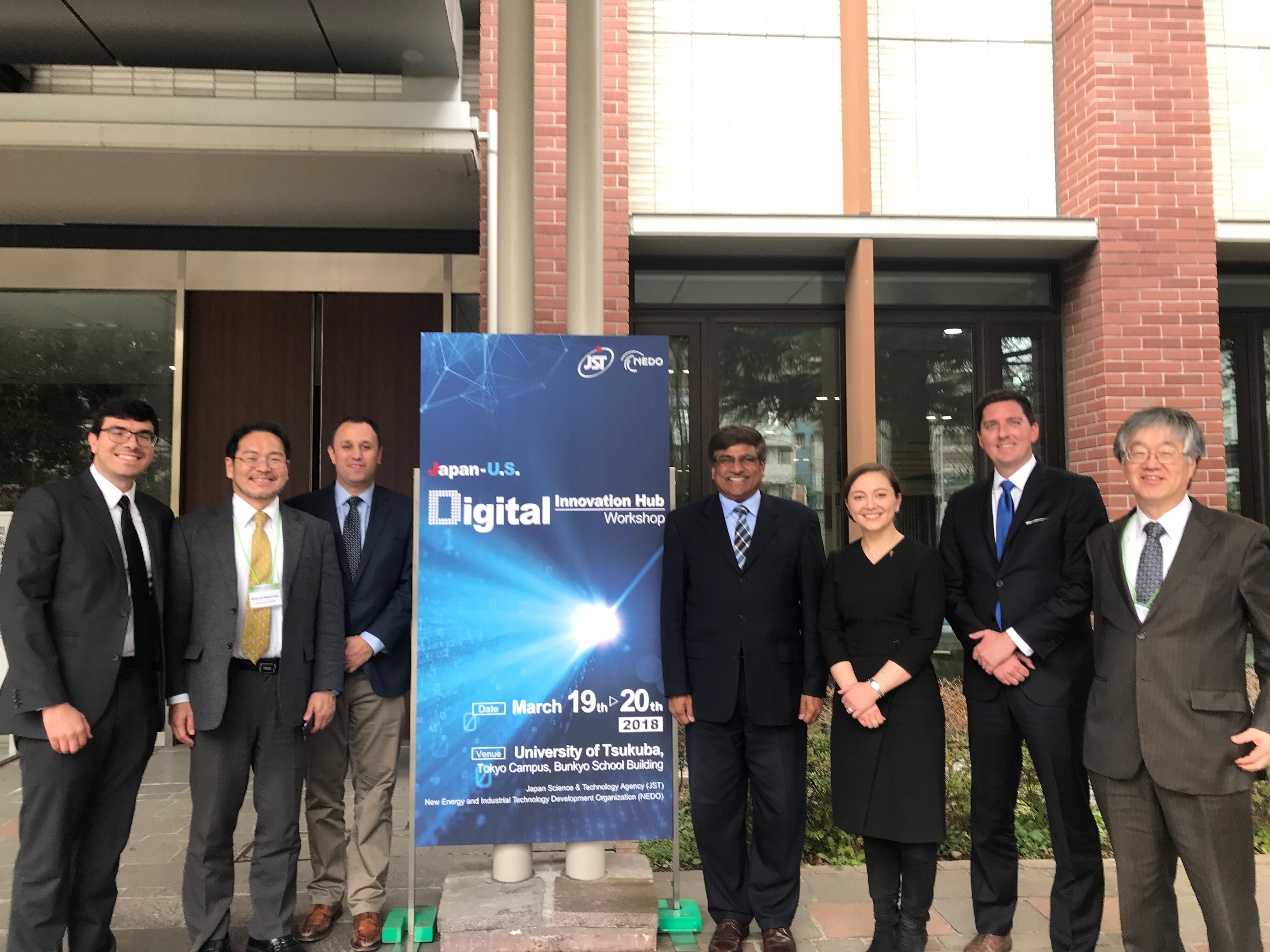 Picture of professionals and students posing in front of a sign.