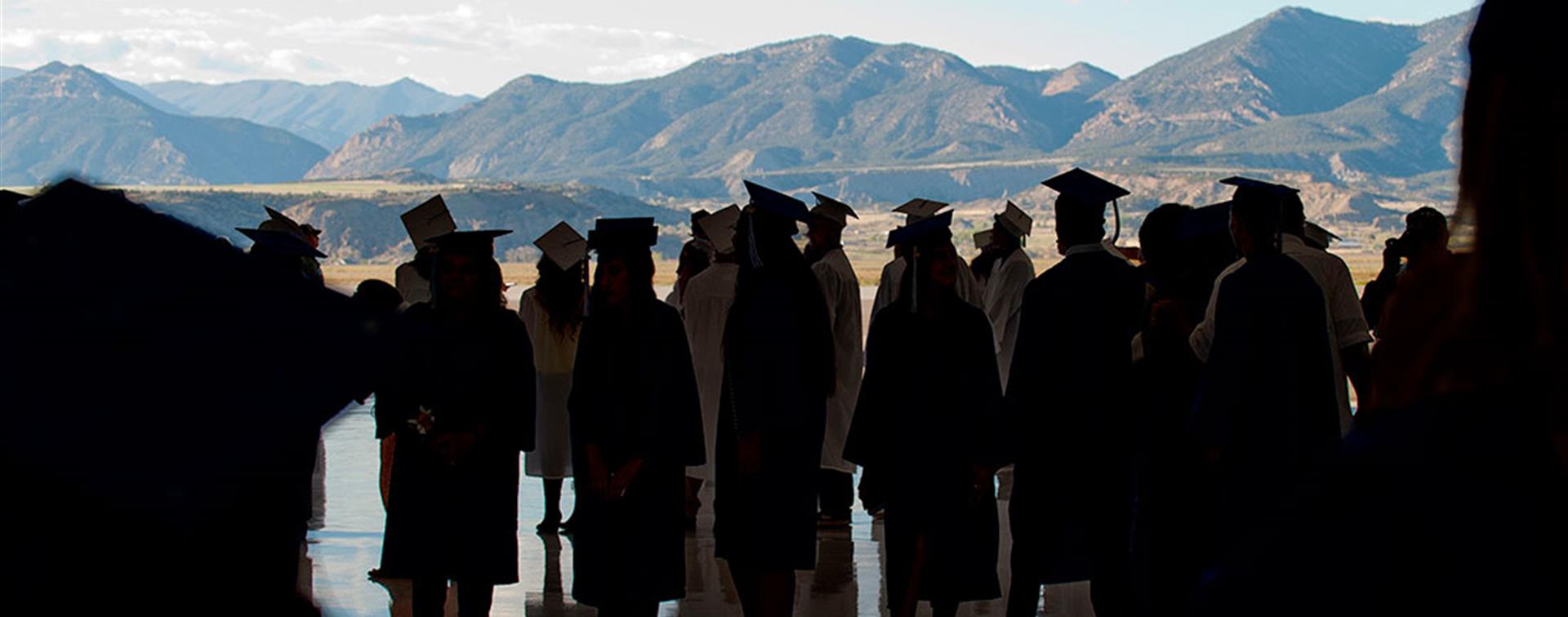 Colorado Mountain College graduates standing before a mountain backdrop
